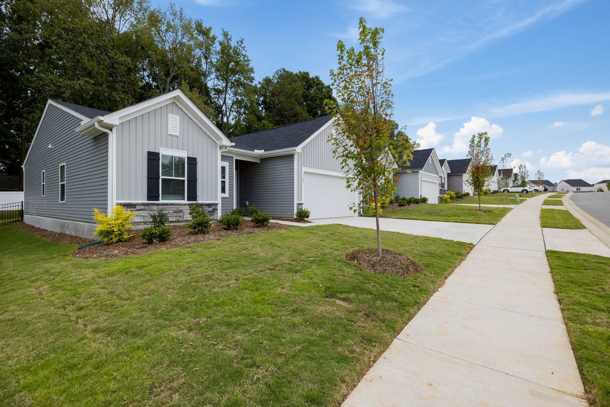 a row of houses with a sidewalk in front of them in a residential area .