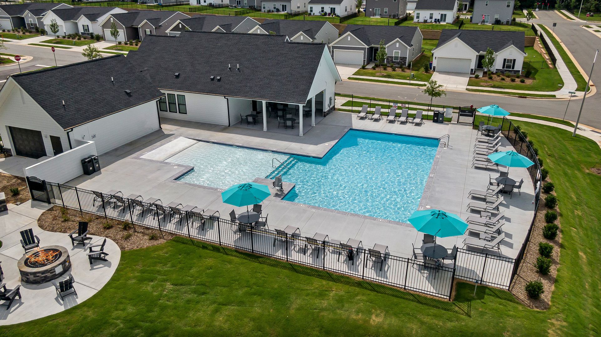 an aerial view of a swimming pool in a residential area surrounded by houses .
