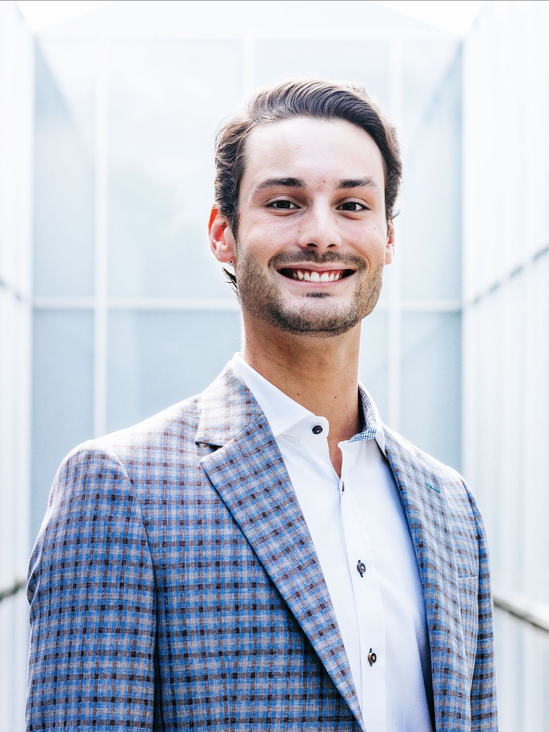 a man in a suit and white shirt is smiling for the camera .