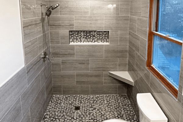 A remodeled bathroom with a shower, toilet, and window.