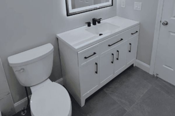 A bathroom with a toilet a sink and a mirror