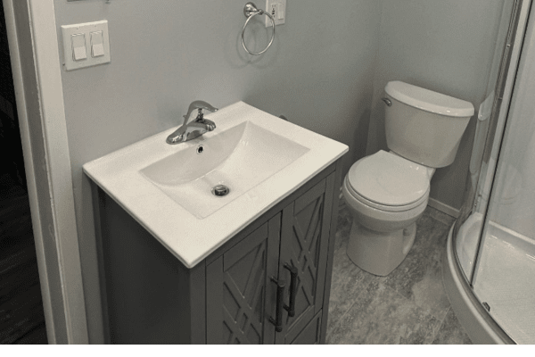 A bathroom with a sink , toilet and shower.