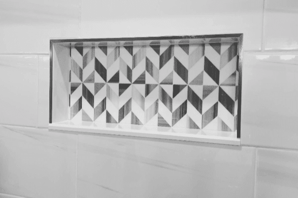 A black and white photo of a shower niche with a geometric pattern on it.