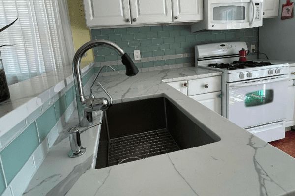 A kitchen with a sink , stove and microwave