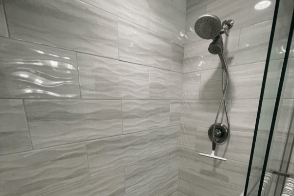 A shower with a shower head and a sliding glass door.