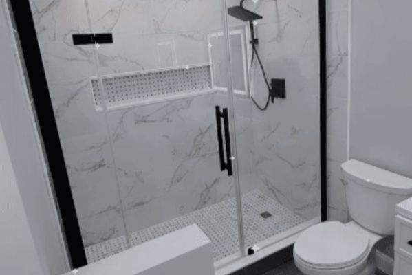 A bathroom with a toilet and a shower with a glass door.