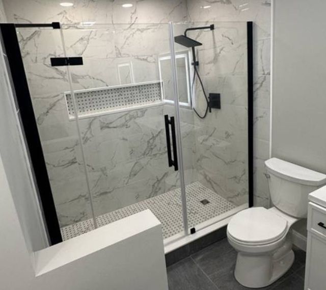 A bathroom with a toilet and a shower with a glass door.