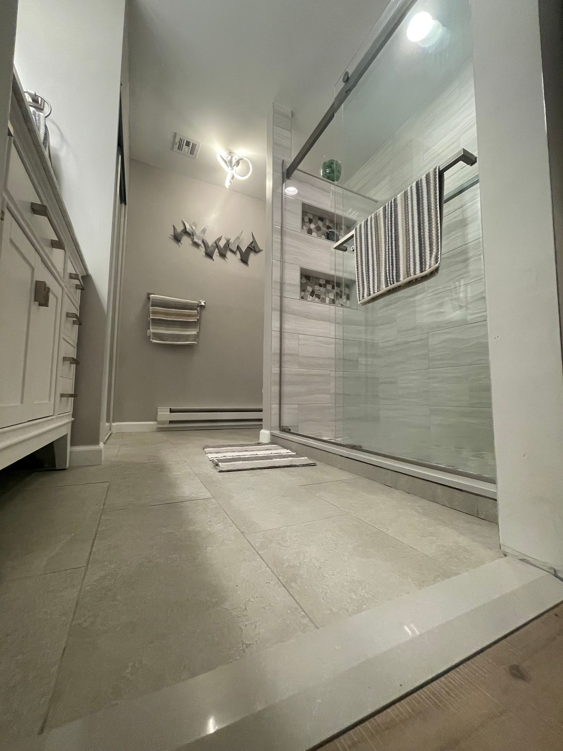 A bathroom with a walk in shower and a towel rack.