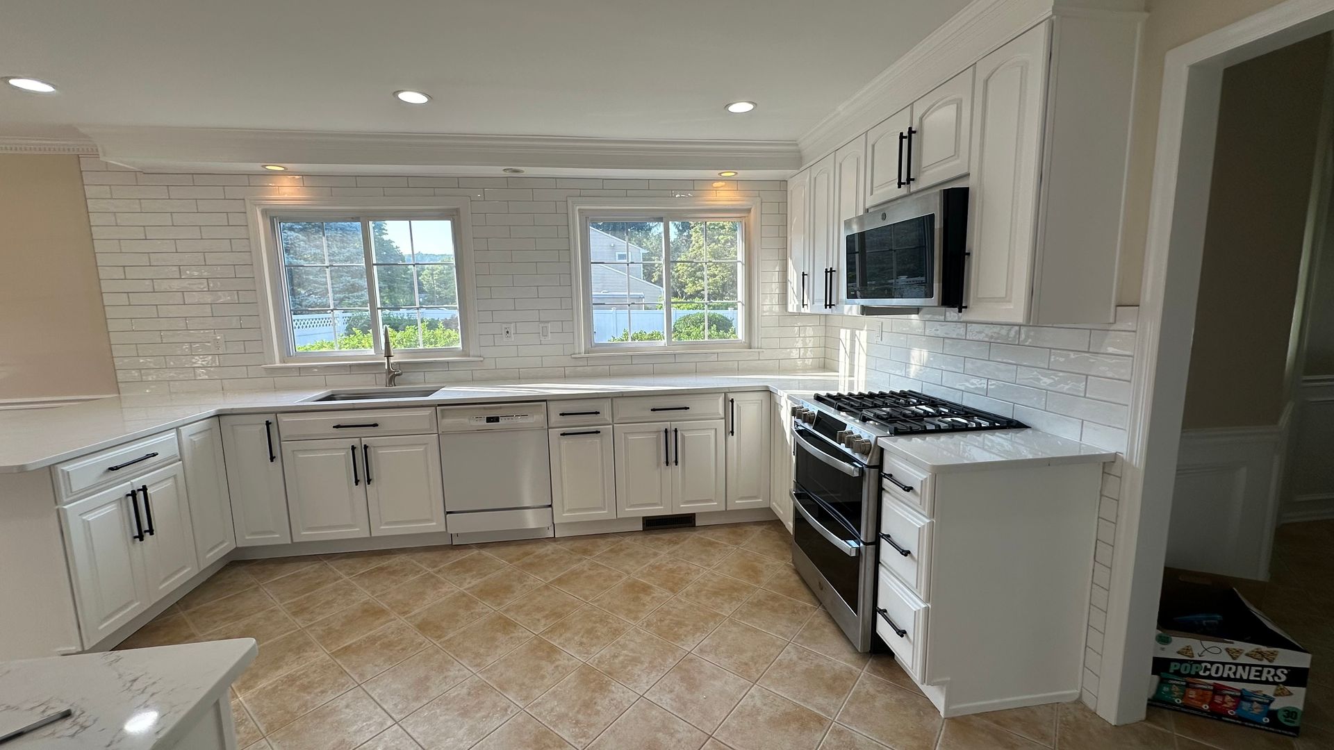 A kitchen with white cabinets and stainless steel appliances.