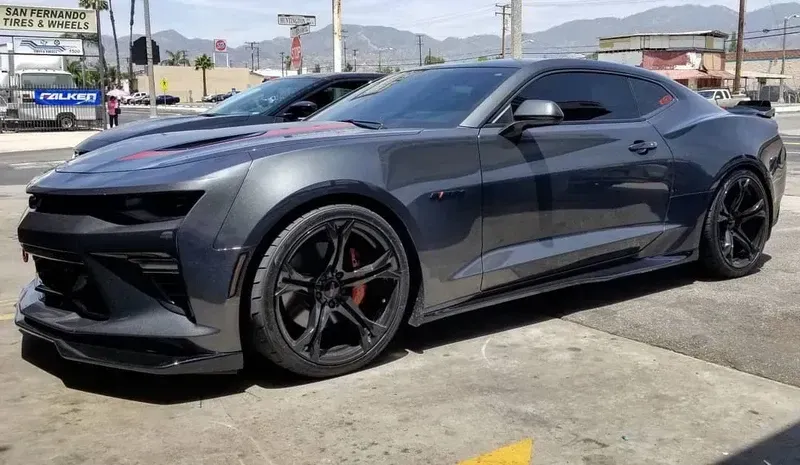 Gray Chevrolet Camaro with black rims parked on a city street.