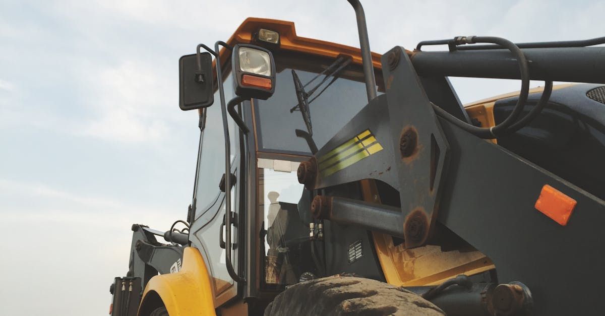 A yellow and black tractor is parked in a field.