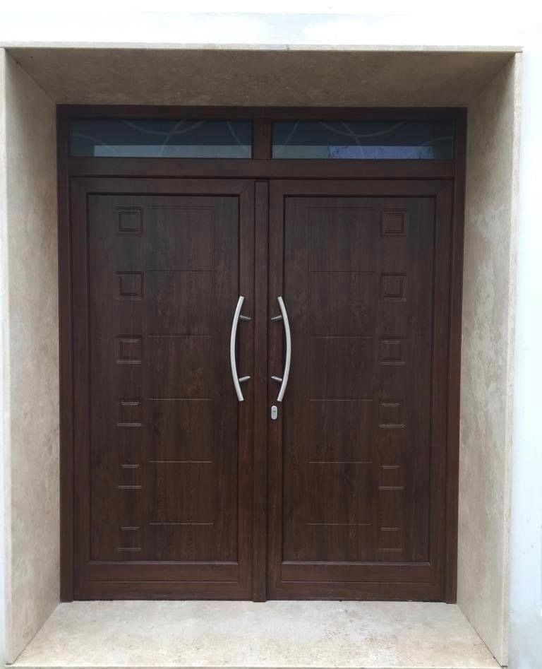 Doppie porte d'ingresso marroni con maniglie argentate e finestre a traversa.