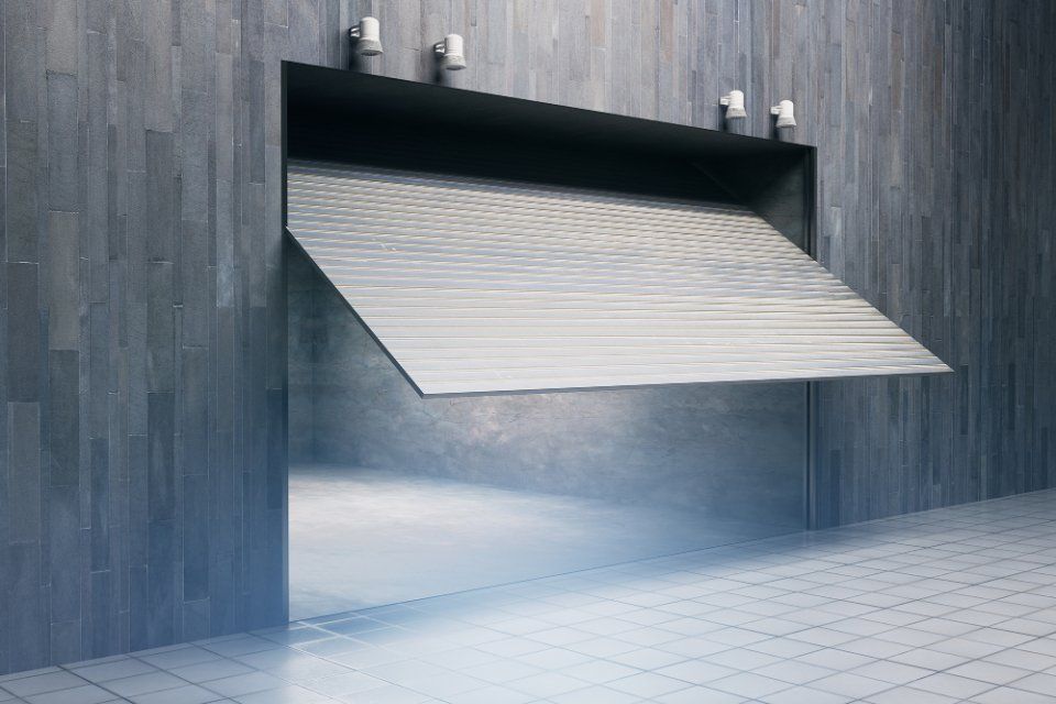 La porta del garage è parzialmente aperta, rivelando un interno luminoso, situato in un edificio moderno