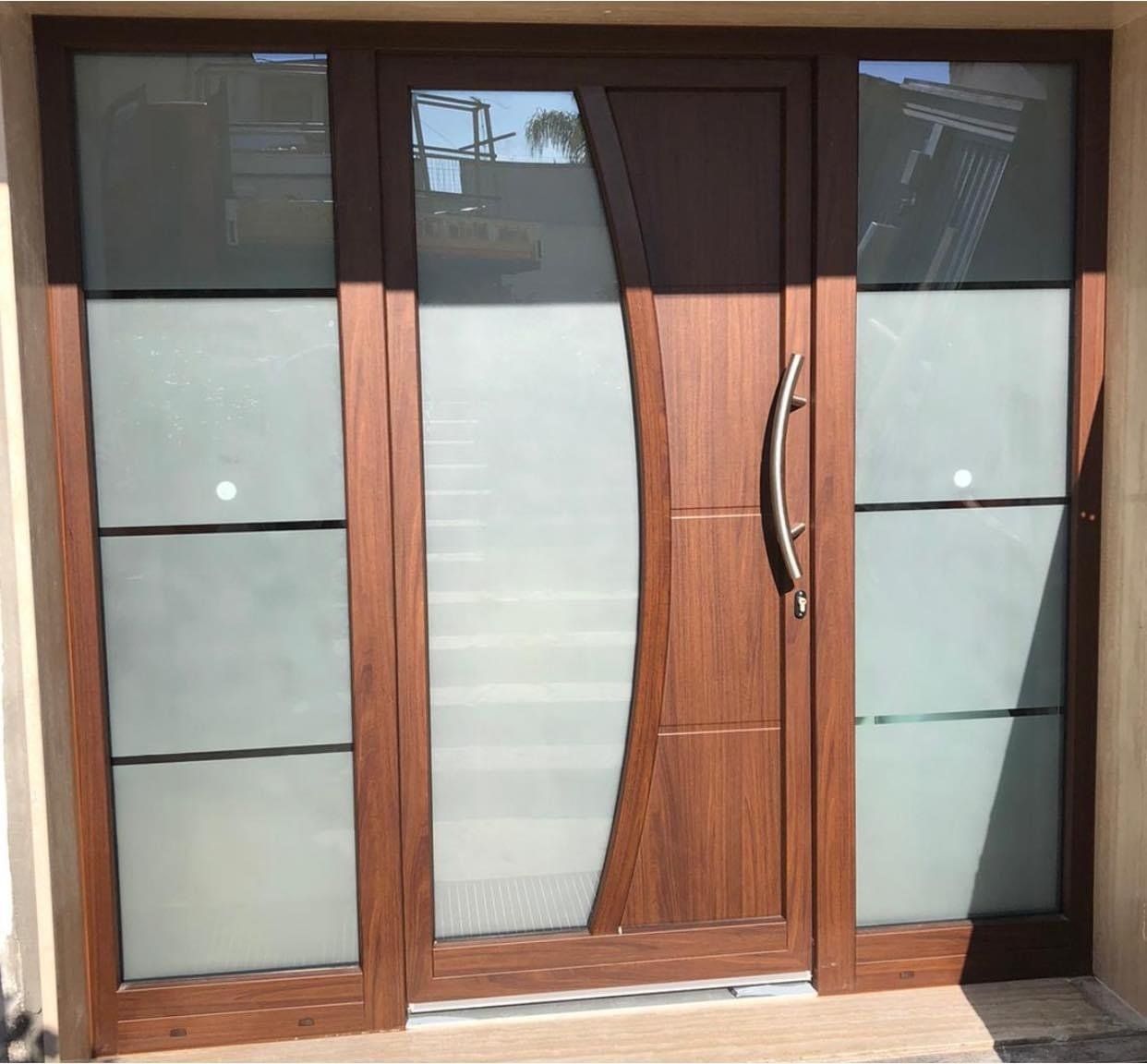 Porta in legno con pannelli in vetro smerigliato e vetri laterali.