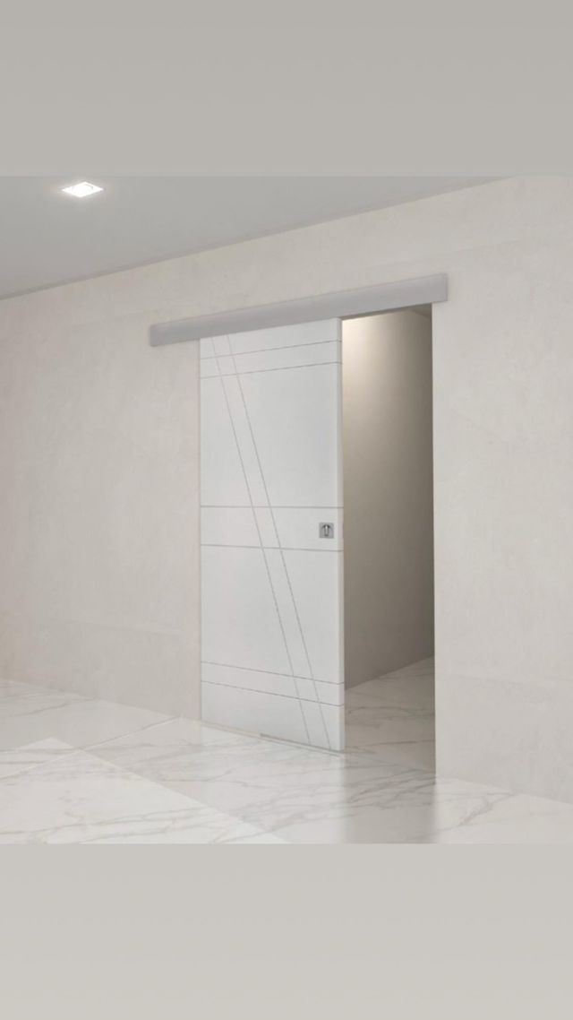 Porta scorrevole bianca, design minimalista, incassata nel muro, aperta su una stanza luminosa.