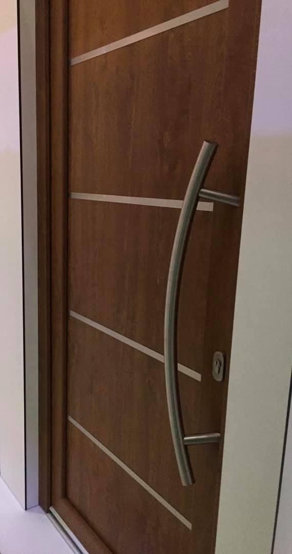 Porta in legno marrone con maniglia argentata e dettagli orizzontali argentati.