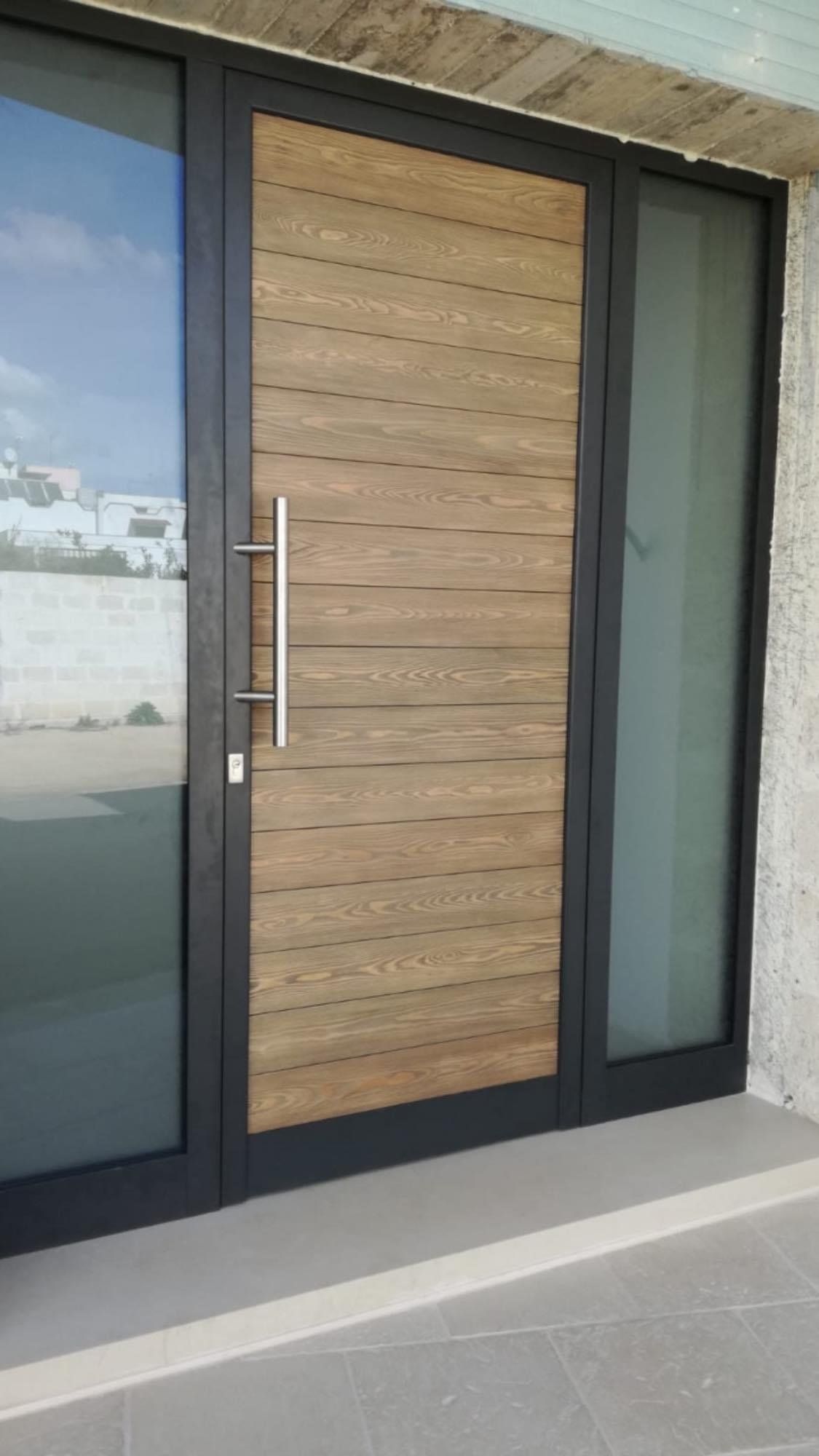 Porta in legno con pannelli laterali in vetro, telaio scuro, maniglia argentata e pannelli orizzontali in legno chiaro.