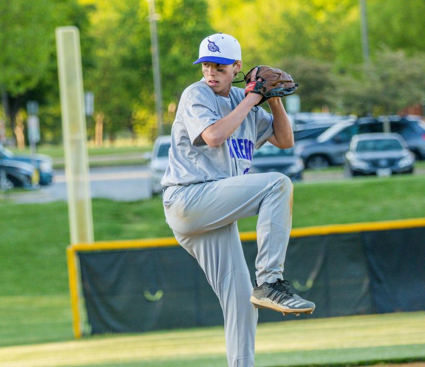 Basketball about to go through a hoop.