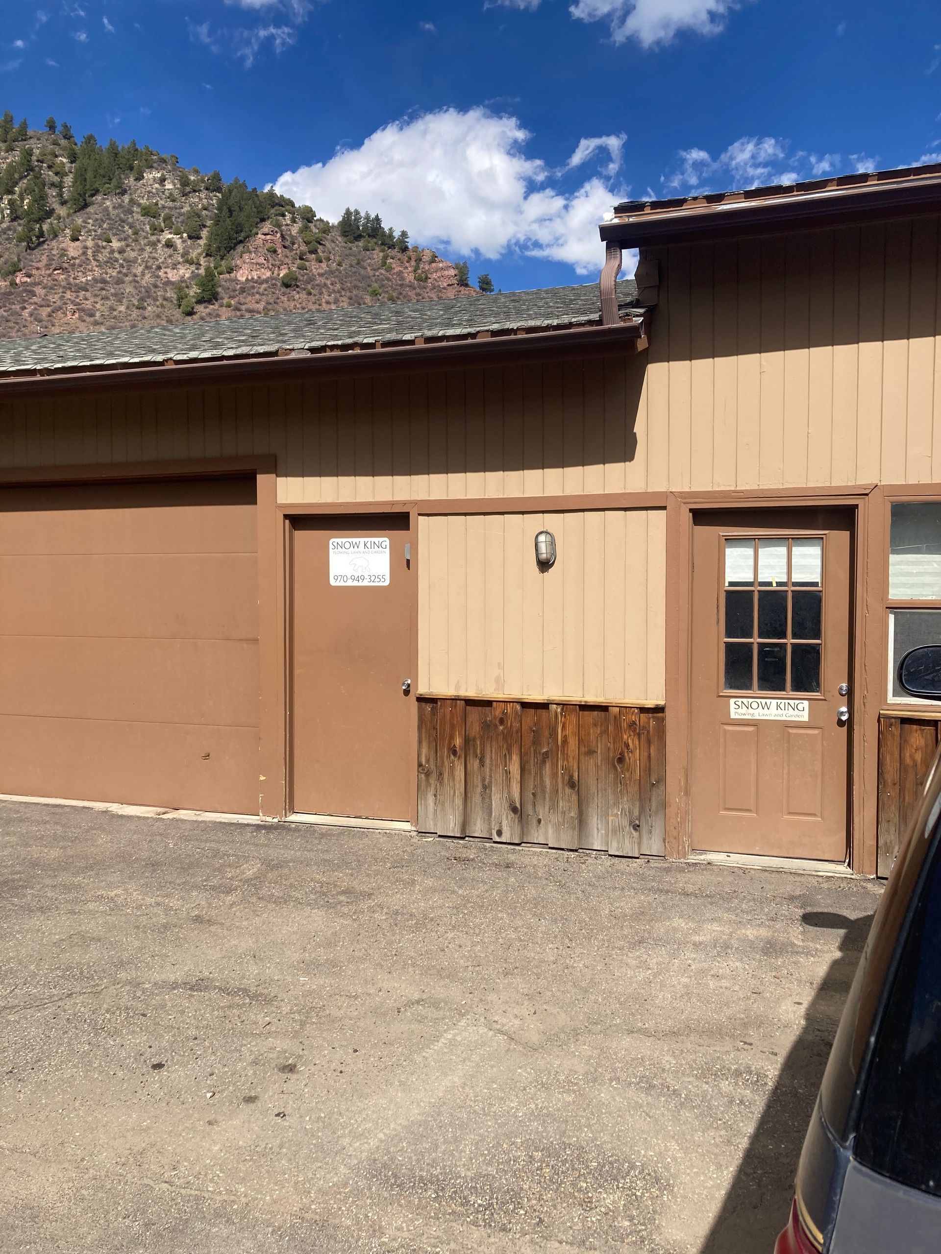 A brown building with a car parked in front of it