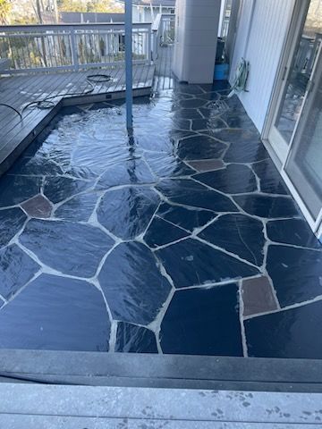 A patio with a pool in the middle of it and a sliding glass door.