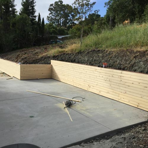 A wooden wall is being built on a concrete surface