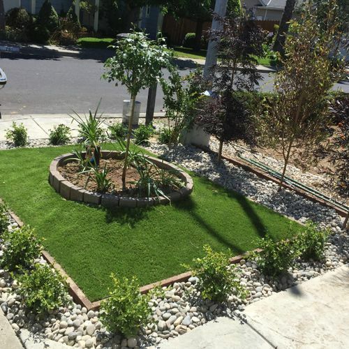 A lush green lawn with a circular garden in the middle
