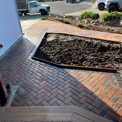 A brick walkway with a truck parked in the background