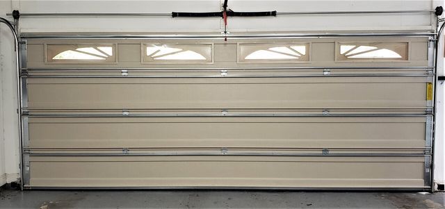 A garage door is open and sitting in a garage.