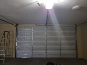 A garage with a large garage door and a ladder.