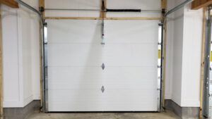 A white garage door is open in a garage.