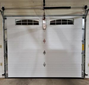 A white garage door is open in a garage.