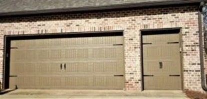 Brick garage with two brown panel doors.