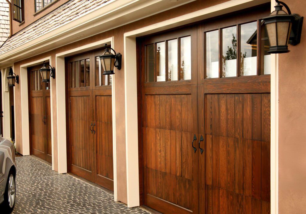 A car is parked in front of a row of wooden garage doors.