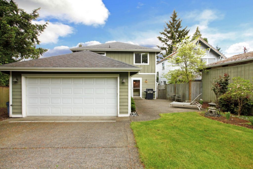 A house with a garage and a driveway in front of it.