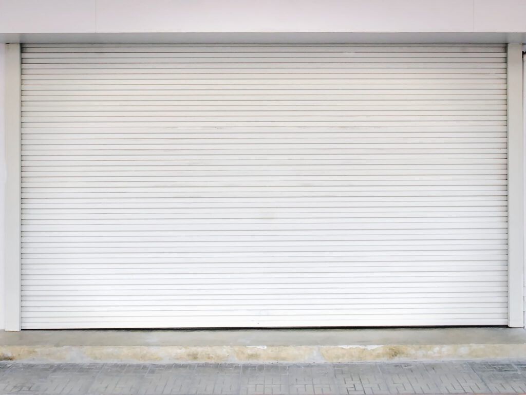 A white garage door is closed on a building.