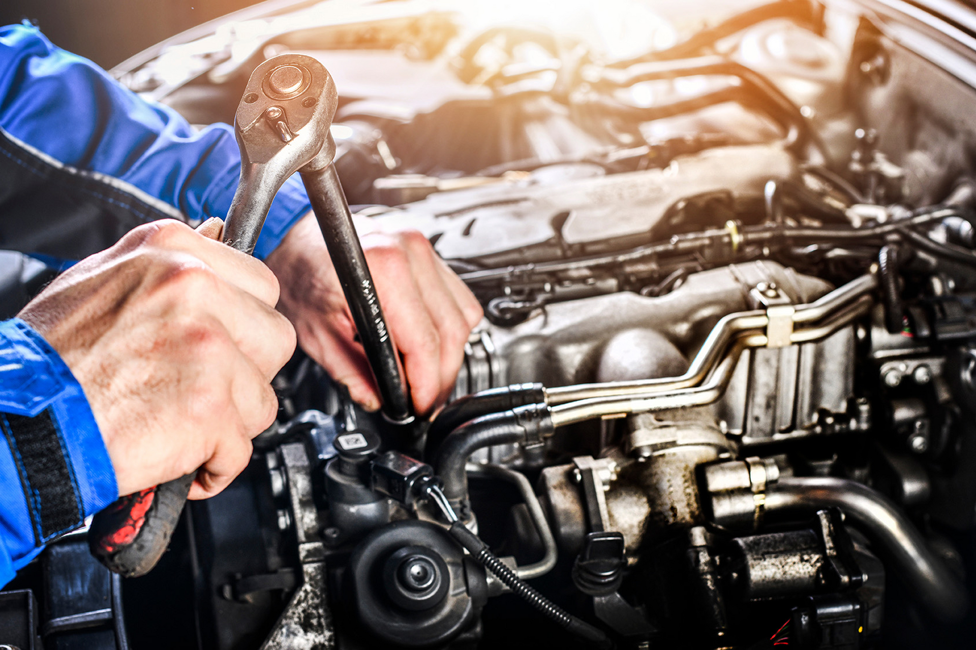 Mechanic using a wrench to repair a car engine.