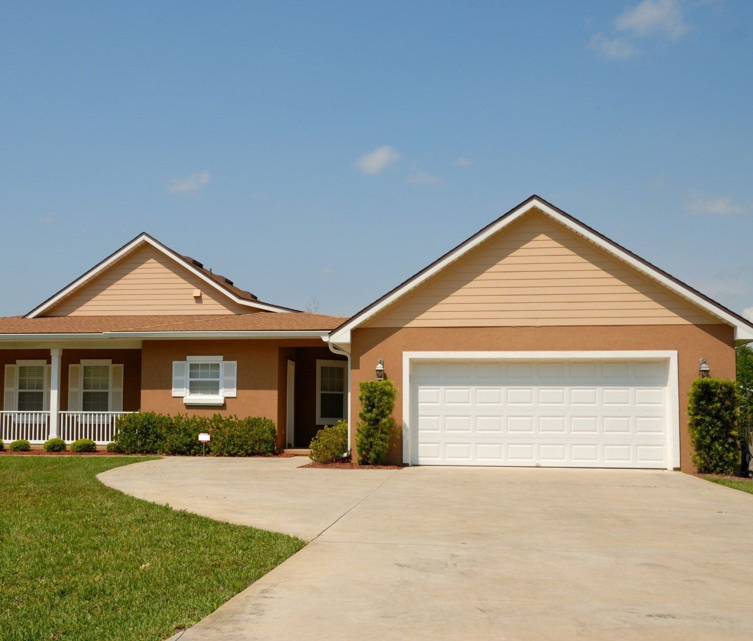 Charming wooden fence encircling a house, set against a lush green lawn.