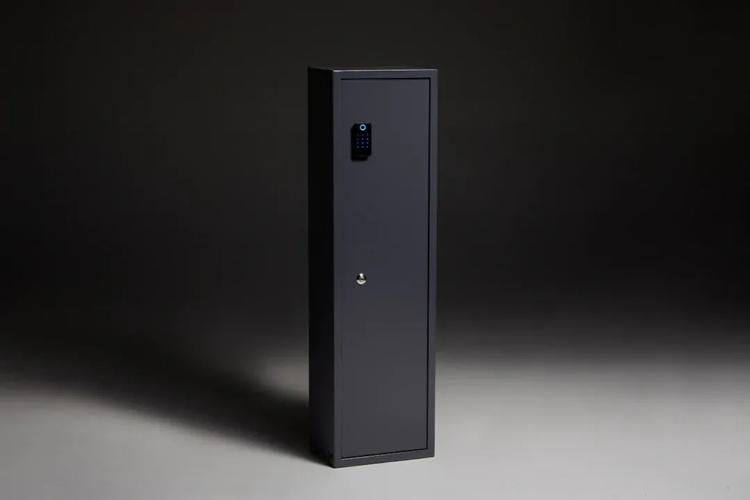 A black safe is sitting on a gray surface in a dark room.