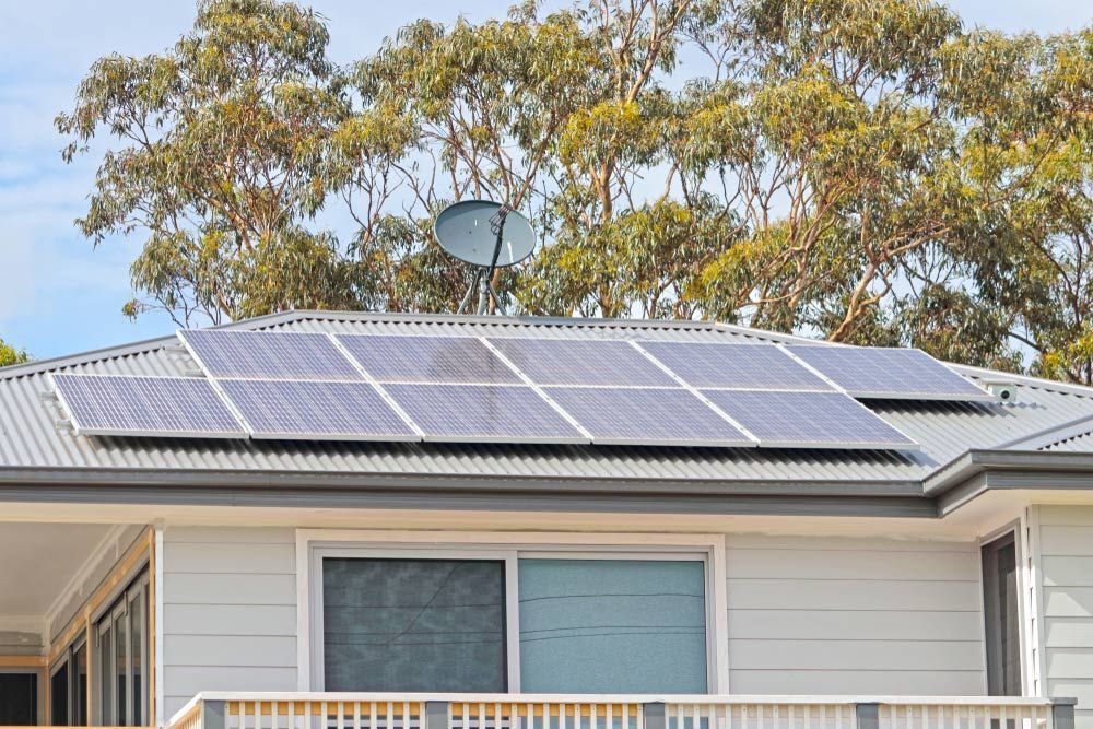 A House With Solar Panels On The Roof And A Satellite Dish — RAFFBRO Electrical Solar & Air Conditioning In Wodonga, VIC