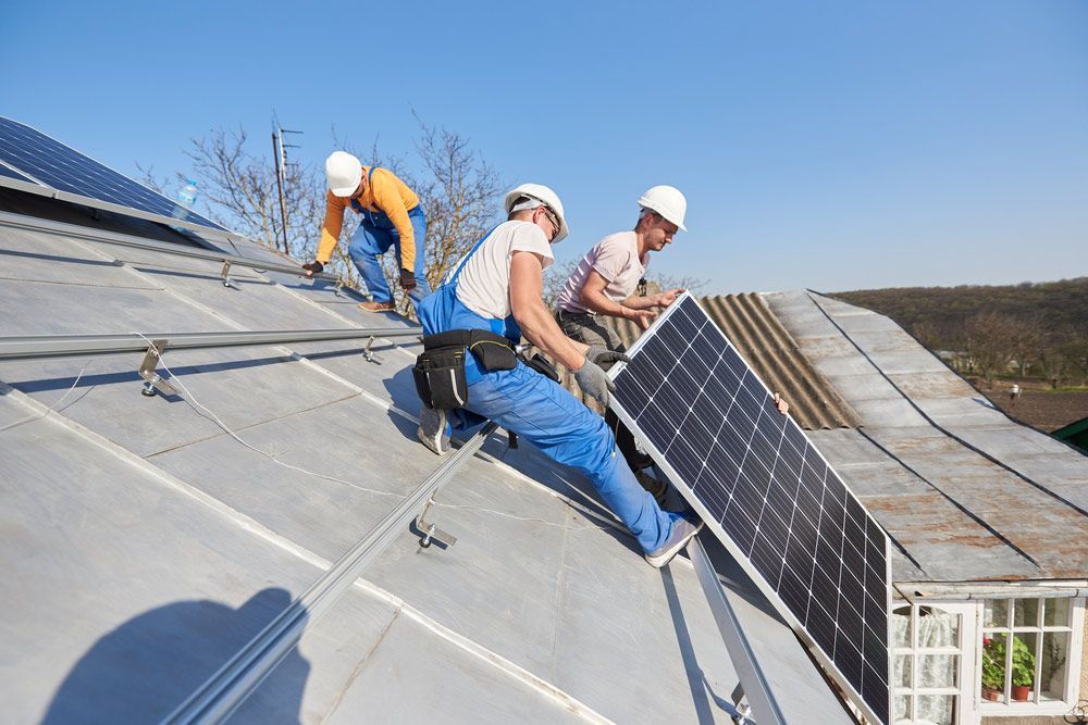 A Group Of Men Are Installing Solar Panels On A Roof — RAFFBRO Electrical Solar & Air Conditioning In Wodonga, VIC