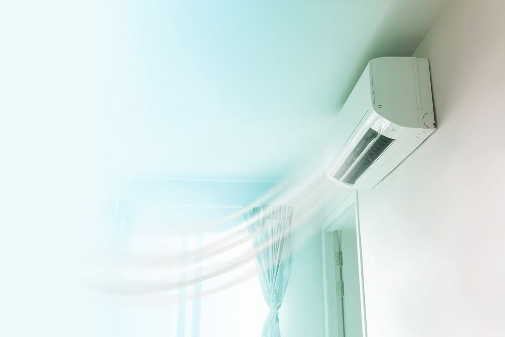 Air Conditioner Is Blowing Air Out Of A Window In A Room — RAFFBRO Electrical Solar & Air Conditioning In Wodonga, VIC