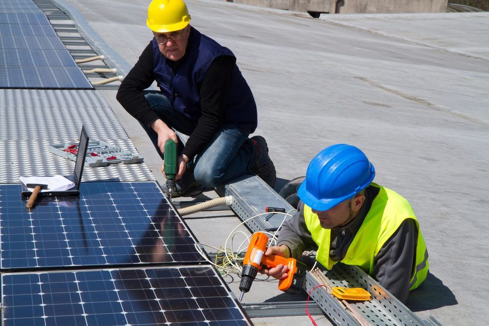 Two Men Are Installing Solar Panels On A Roof — RAFFBRO Electrical Solar & Air Conditioning In Wodonga, VIC