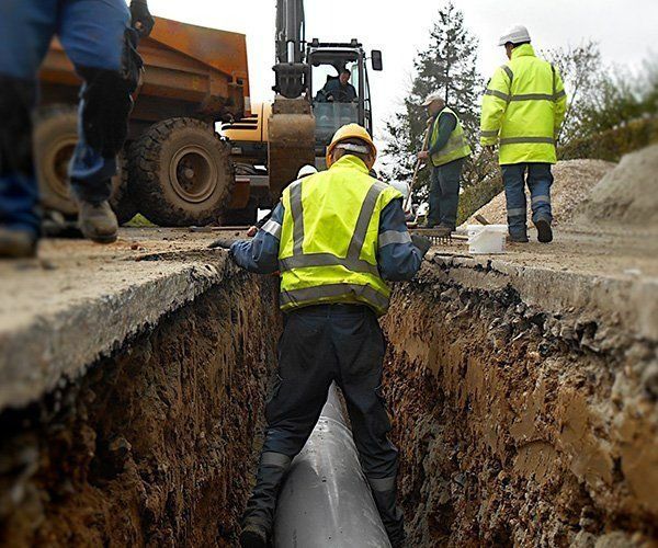 Construction Workers Are Working On A Pipe In A Trench — RAFFBRO Electrical Solar & Air Conditioning In Wodonga, VIC