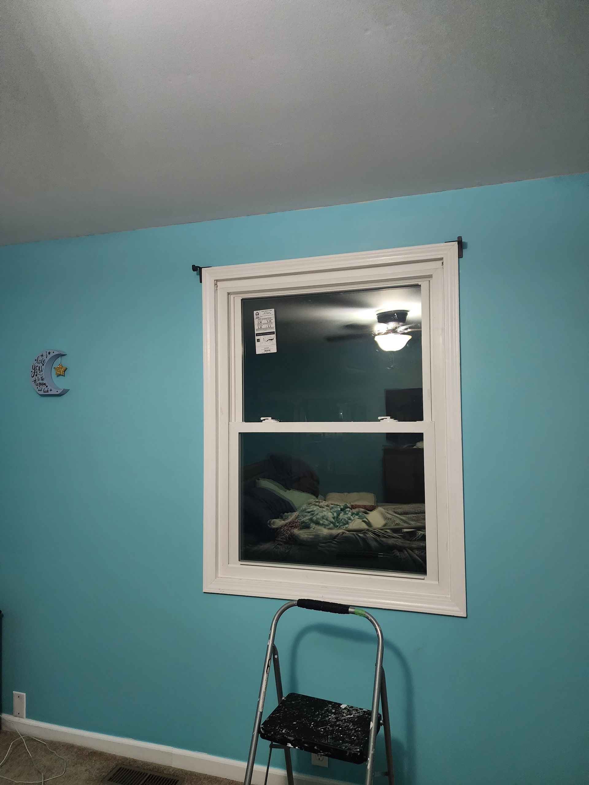 A bedroom with blue walls and a white window