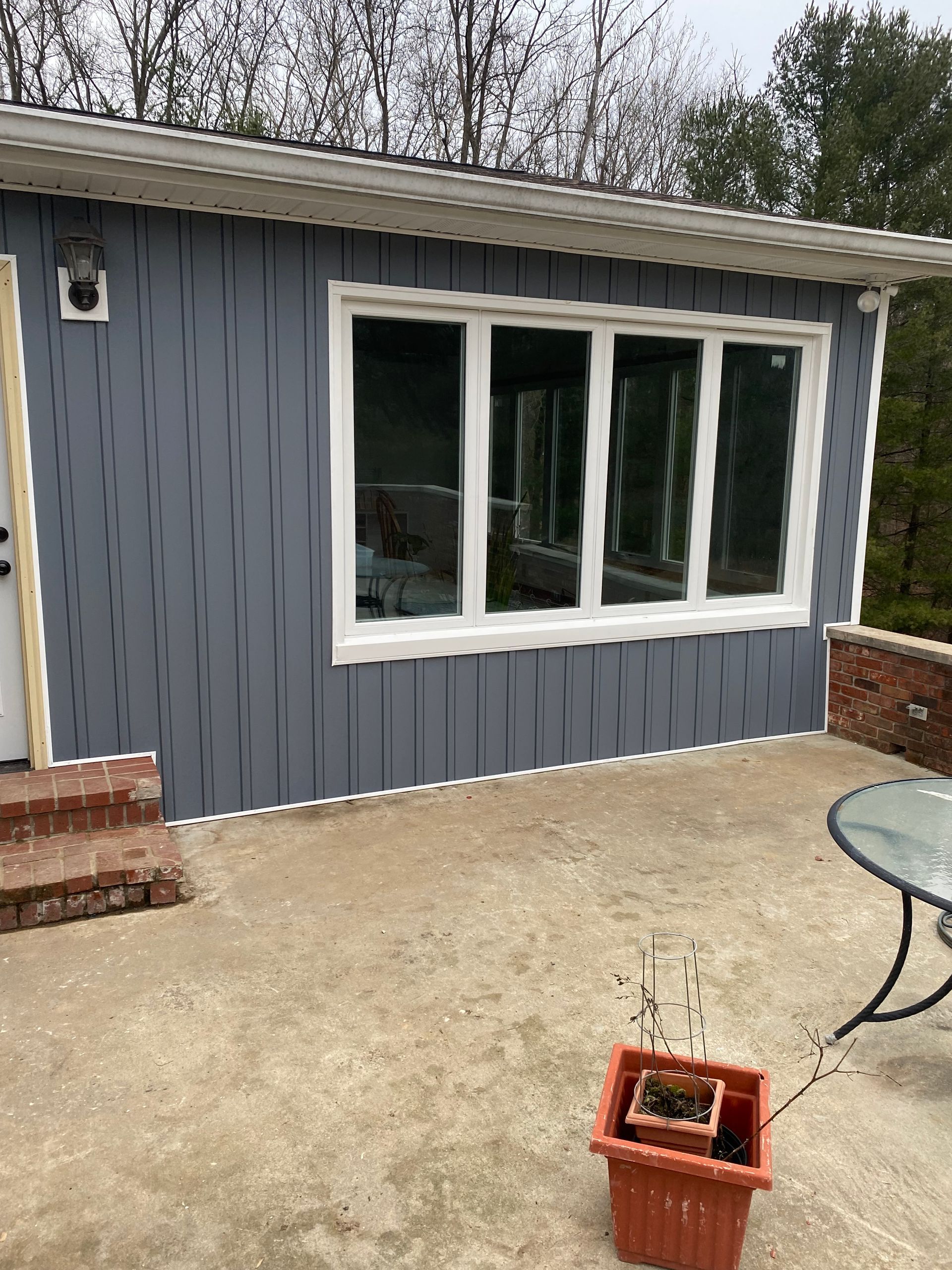 A small house with a patio and a table in front of it.