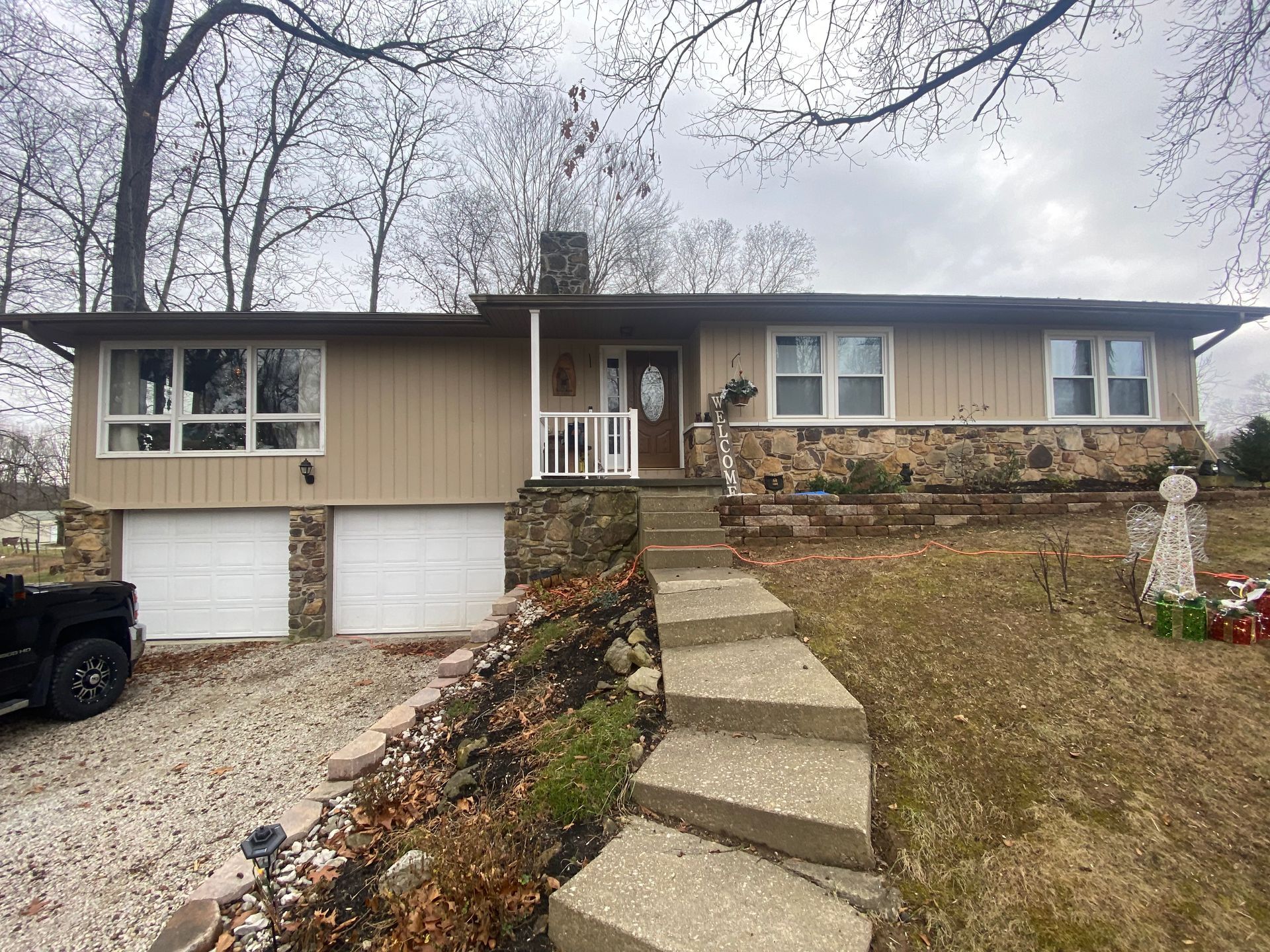A house with stairs leading up to it and a truck parked in front of it.