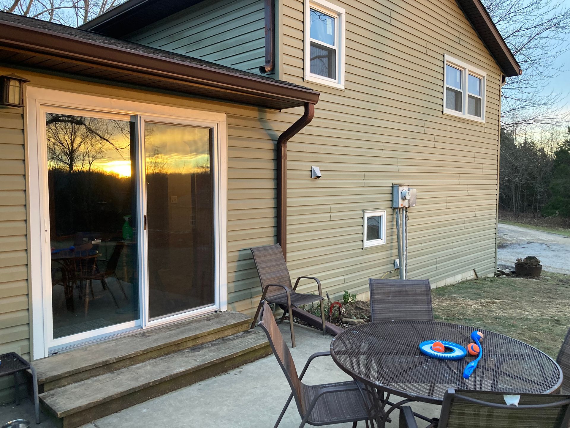 A patio with a table and chairs in front of a house.