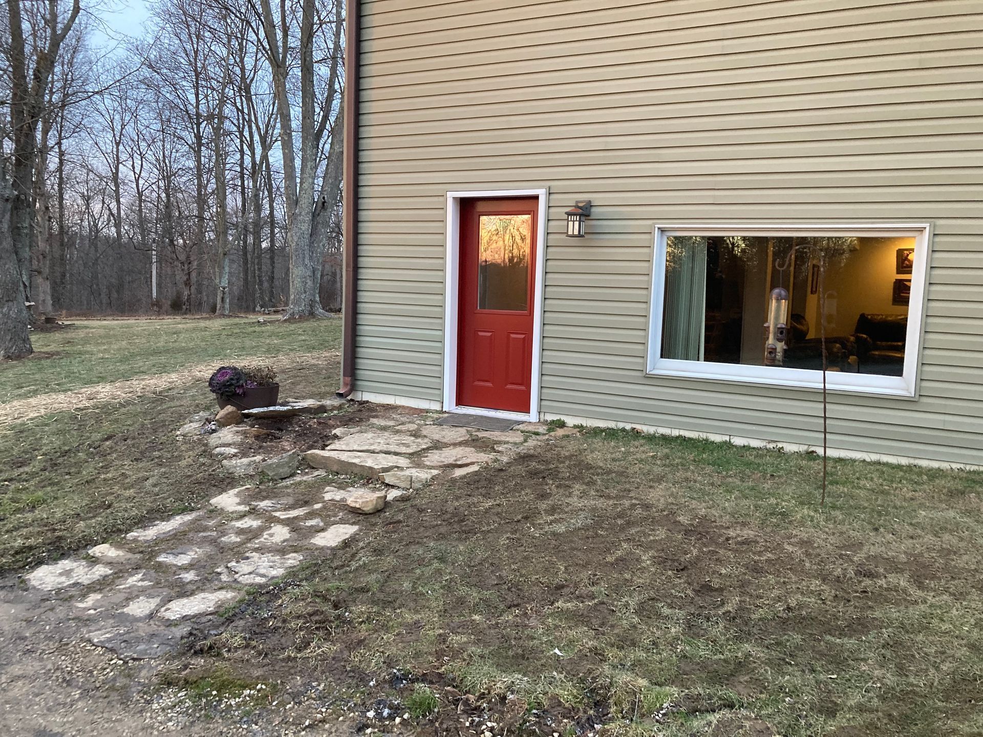 A house with a red door and a walkway leading to it.