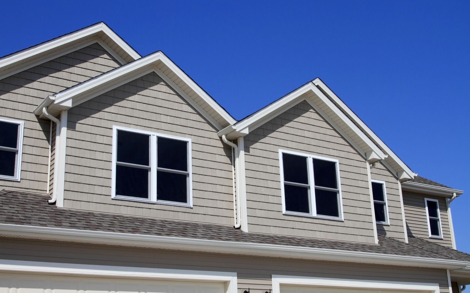 A house with a lot of windows and a blue sky in the background