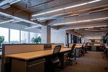 A large empty office with lots of desks and chairs.